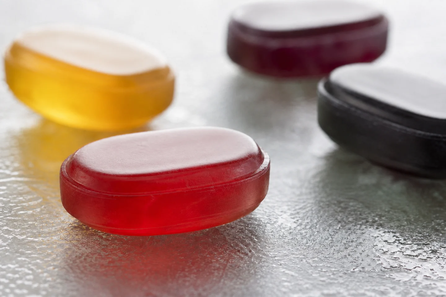 Macro view of translucent red, honey, berry, and licorice throat drops